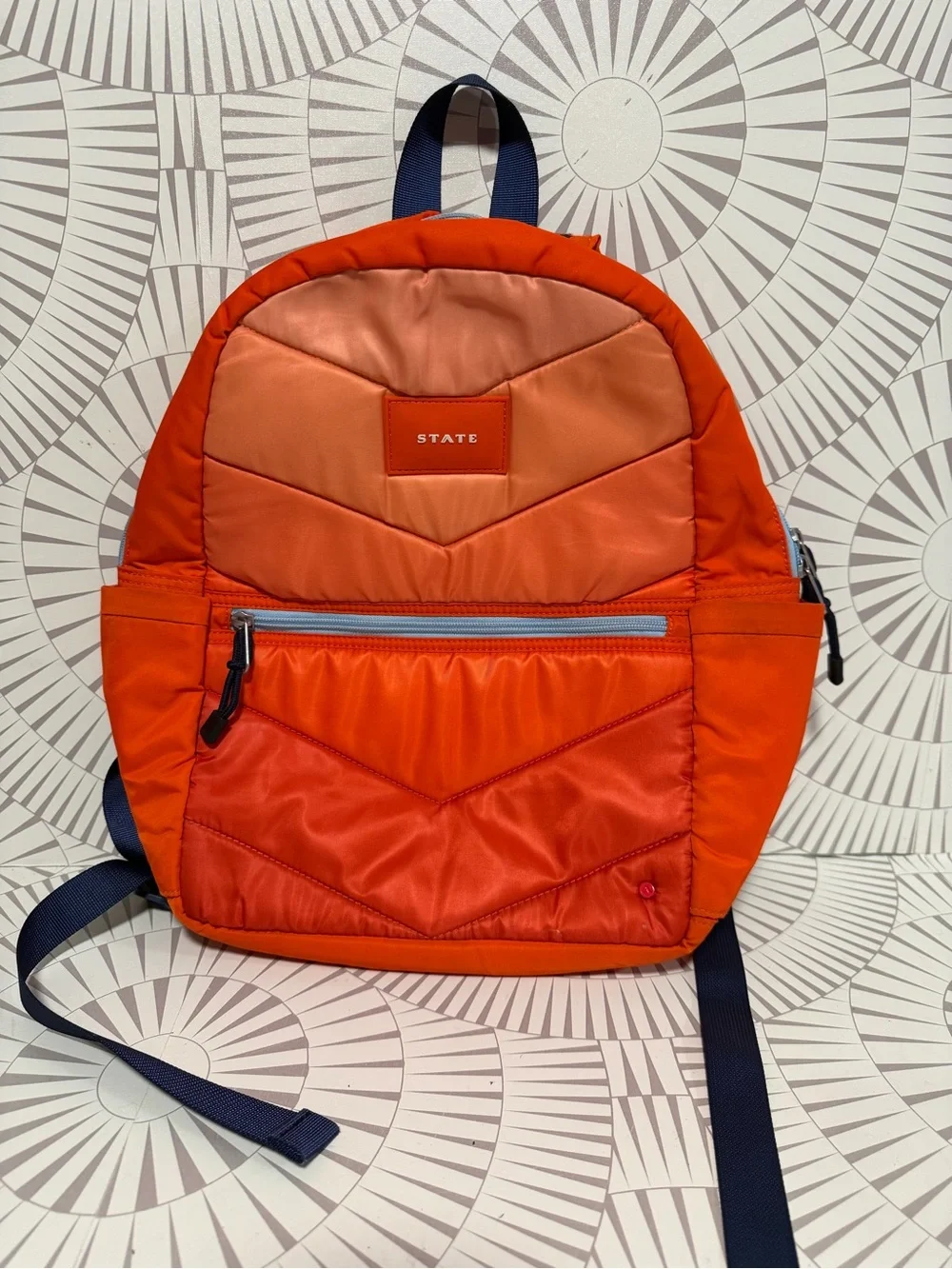 STATE Bags Kane kids backpack in an orange chevron puffer style